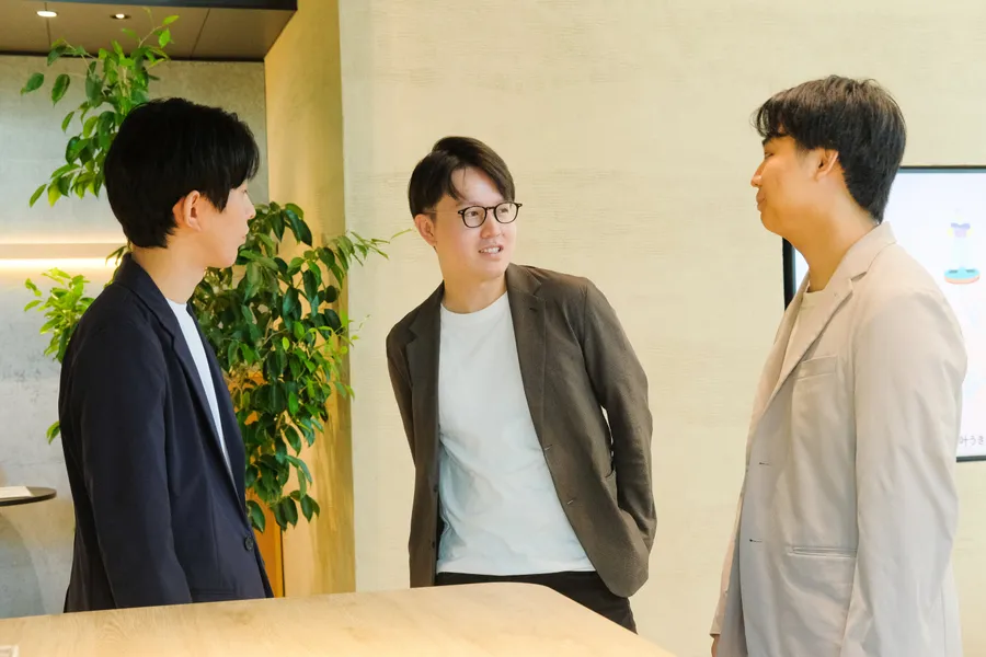 オフィスで立ち話をする株式会社sharedの経営陣3人
